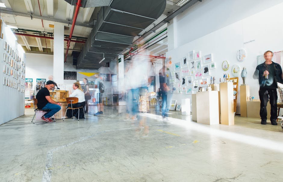 Blurred motion of visitors in a modern art gallery displaying various artworks.