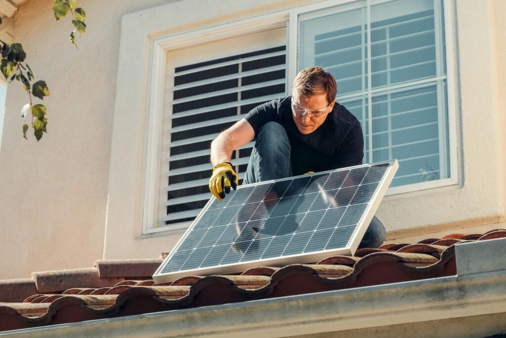 Solar technician installing a photovoltaic panel on a rooftop, promoting renewable energy.